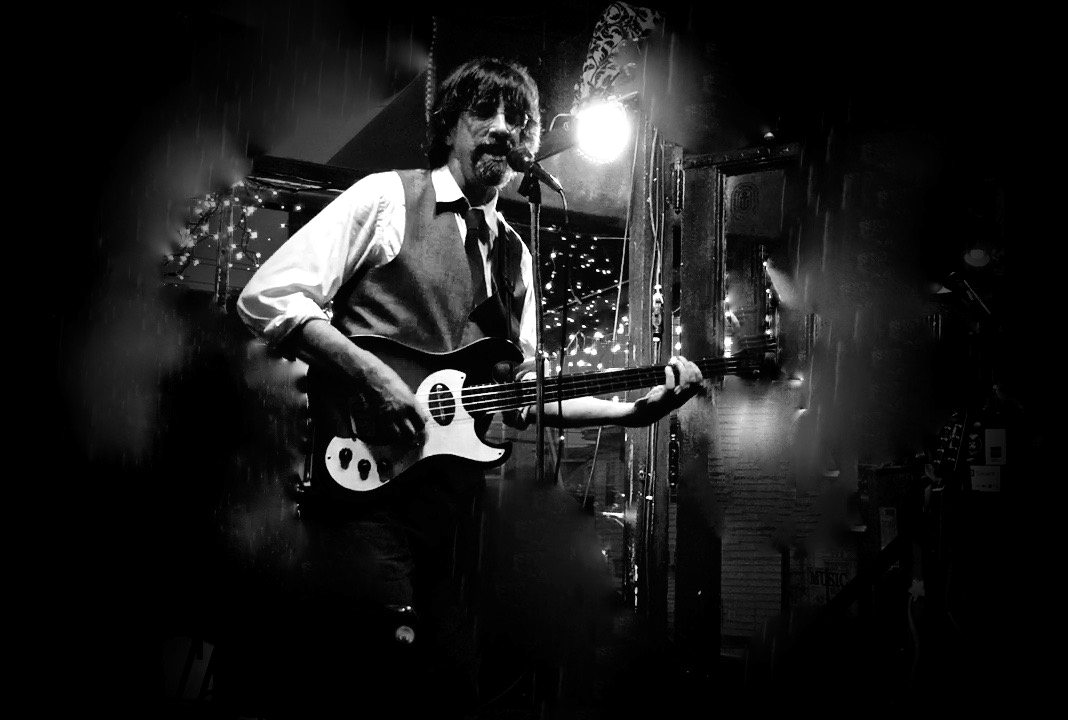 Ritt singing and playing bass in a bar strung with lights