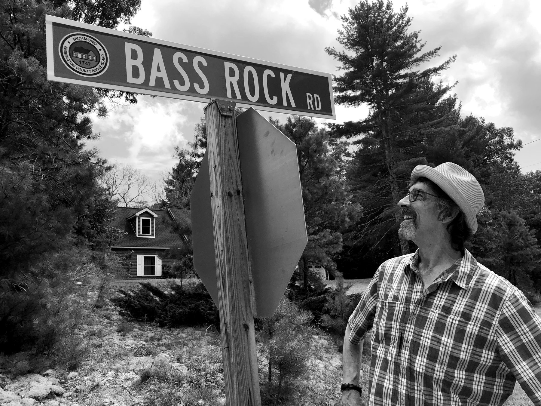 Ritt in a straw hat beneath a Bass Rock Rd street sign