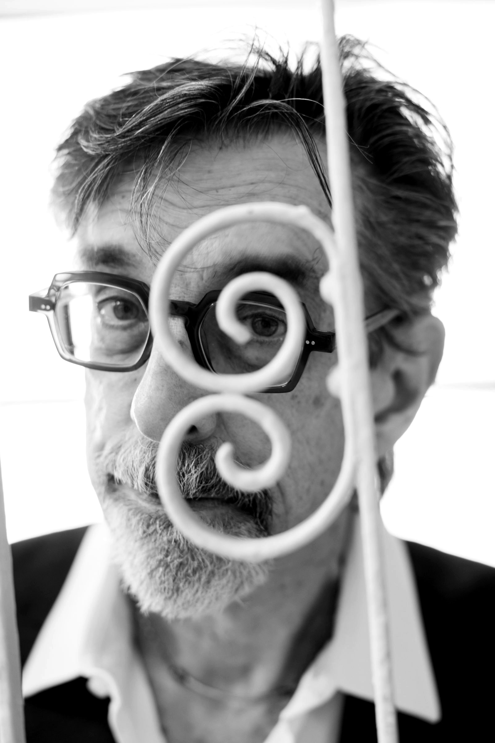 Ritt looking through a curled iron scroll
